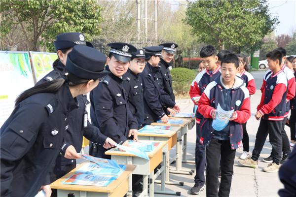 公安民警向学生发放校园安全宣传手册