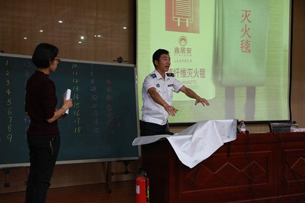陈警官现场演示灭火毯的使用方法