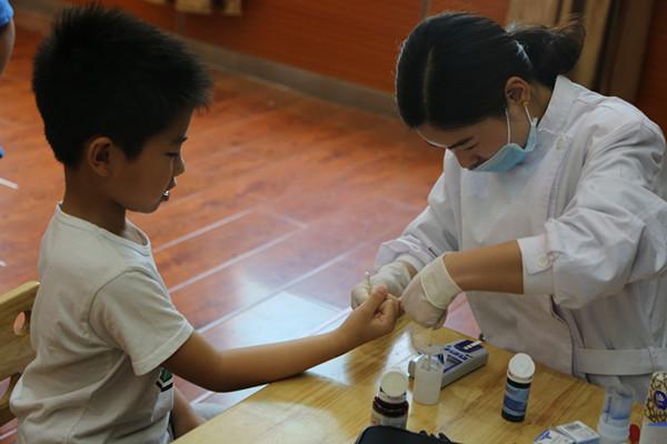 医生在给孩子做“采指血”检查