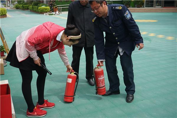 安全小组成员检查灭火器是否能正常使用