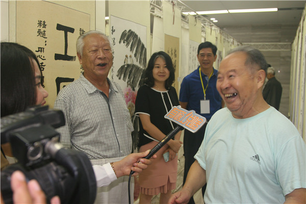 6书画爱好者接受媒体记者采访时，表达了对此次书画展的喜悦之情