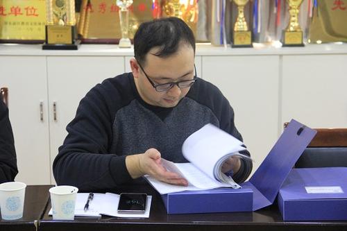 郑东新区基教科刘楠老师正在查阅康平小学的书香校园档案