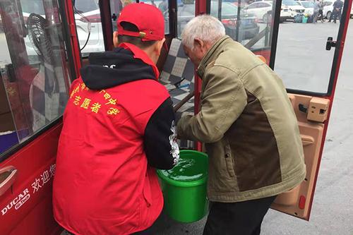 学校志愿者帮助老人提水