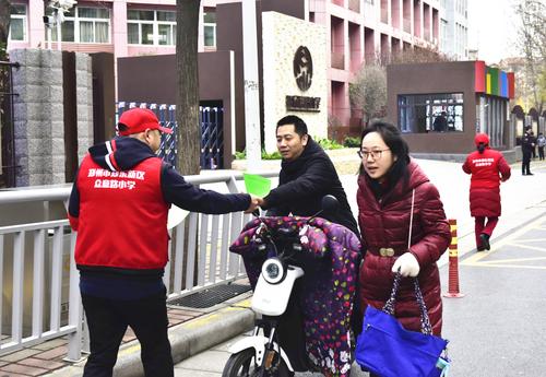 众意路小学教师志愿者为家长发放文明出行倡议书_副本