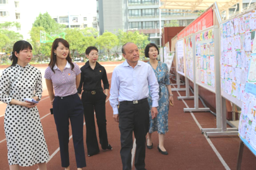 6郑东新区教体局局长田国安和老师们一起参观心理健康优秀作品