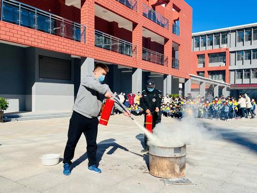 永昌小学教师在消防演练中演示灭火方法