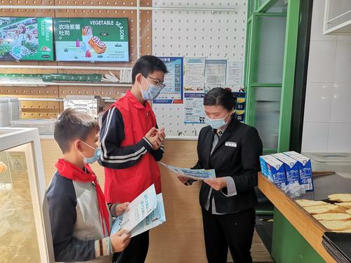团员和少先队员进入社区店铺进行文明交通宣讲
