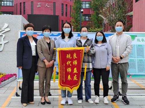 家长代表在征文活动中向郭倩老师赠送锦旗
