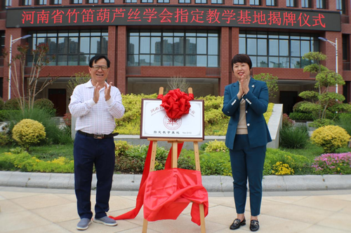 美秀小学校长程丽萍和河南省青年民族乐团团长吴建艺一起揭牌